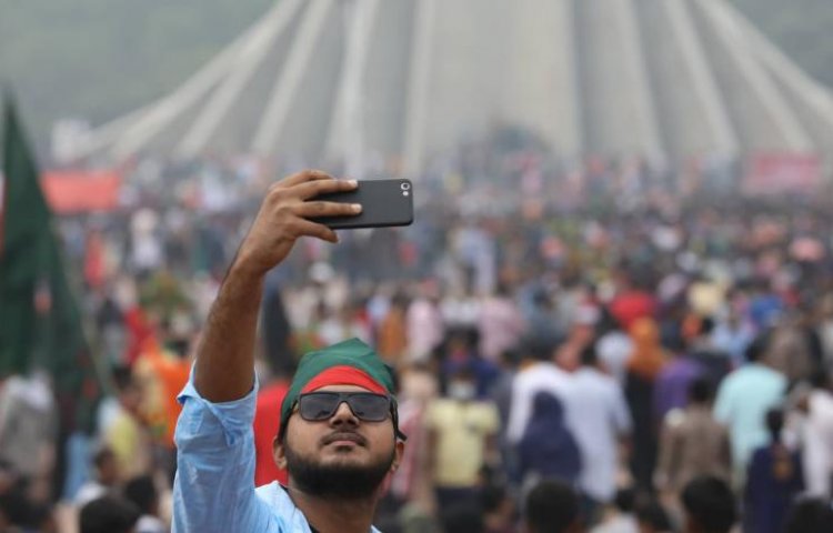 স্মৃতিসৌধের সামনে সেলফি তুলে রাখছেন একজন। 